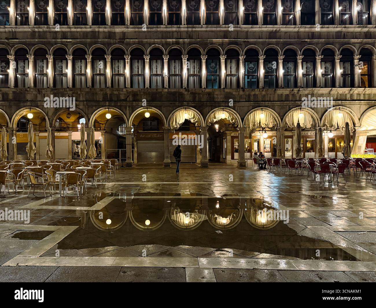 Night view of the Procuratie Vecchie in St Mark's Square, reflected in a puddle after a spring storm, Venice, Veneto, Italy - Smartphone Captured Stock Image