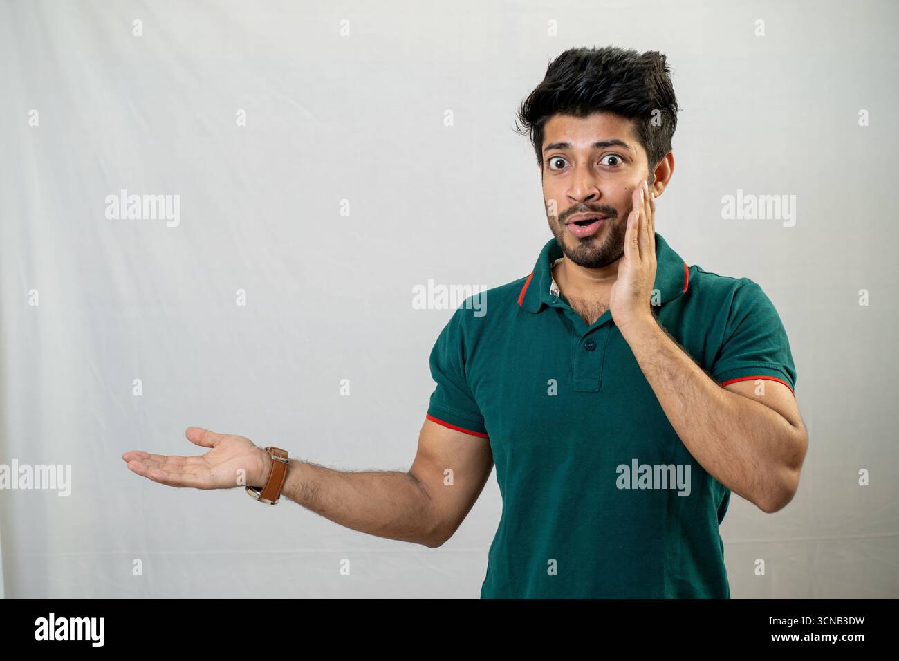 A young man with a surprised expression, with his hands gesturing. Stock Photo