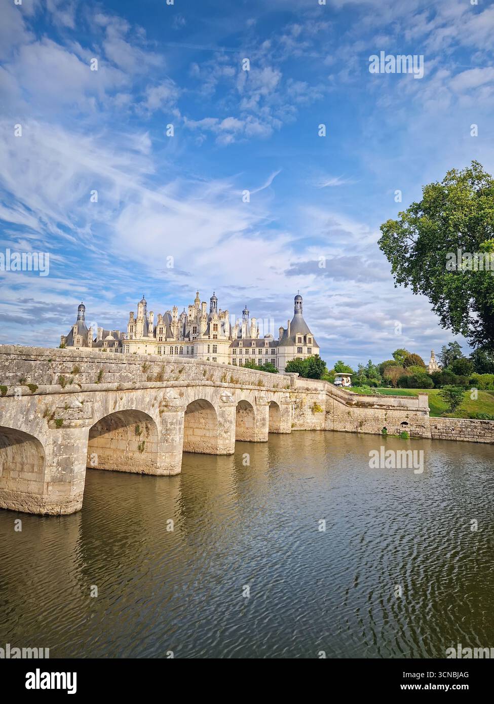 A picturesque stone bridge spans the still water leading to the ...