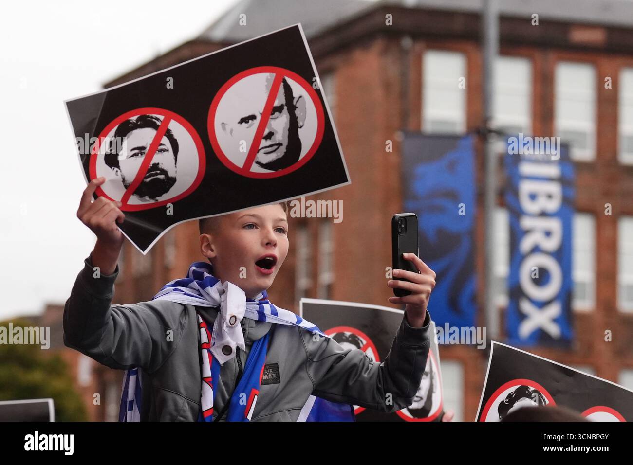 Campaigners hold signs opposing Rangers head coach Russell Martin and ...