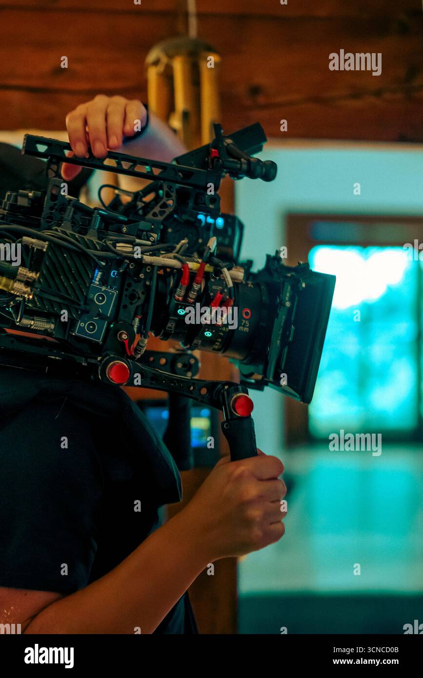 Cinematic camera rig filmmaker handheld setup during indoor video production. Close-up of professional film equipment used for high-quality cinematogr Stock Photo