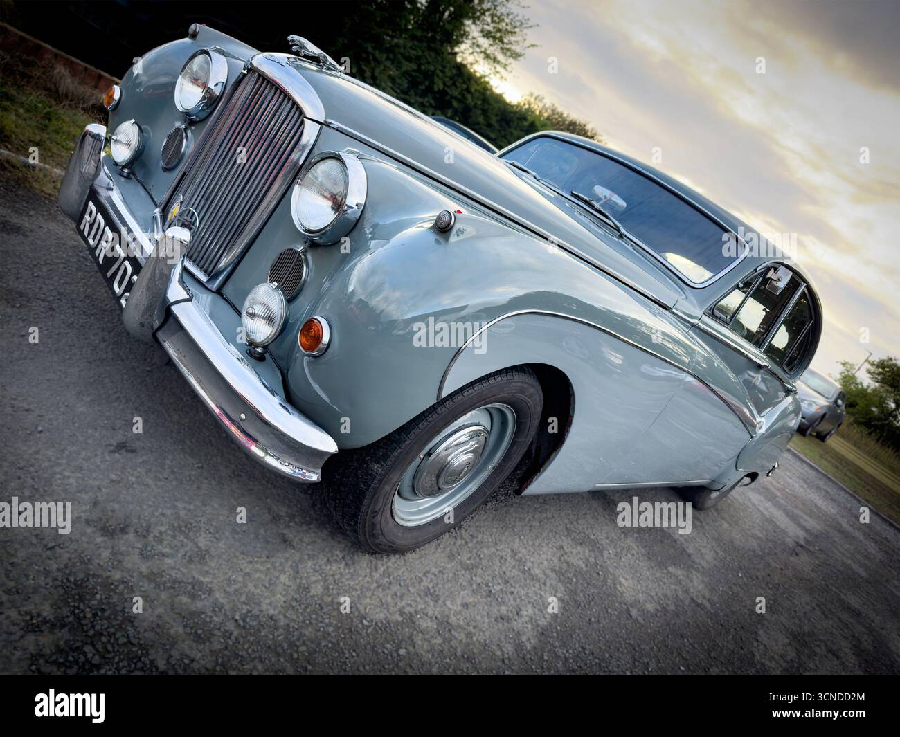 Vintage two-tone grey classic Jaguar Mk 9  or Mk8 car with sleek silver body and chrome detailing parked on a quiet road under a cloudy sky. - Smartphone Captured Stock Image