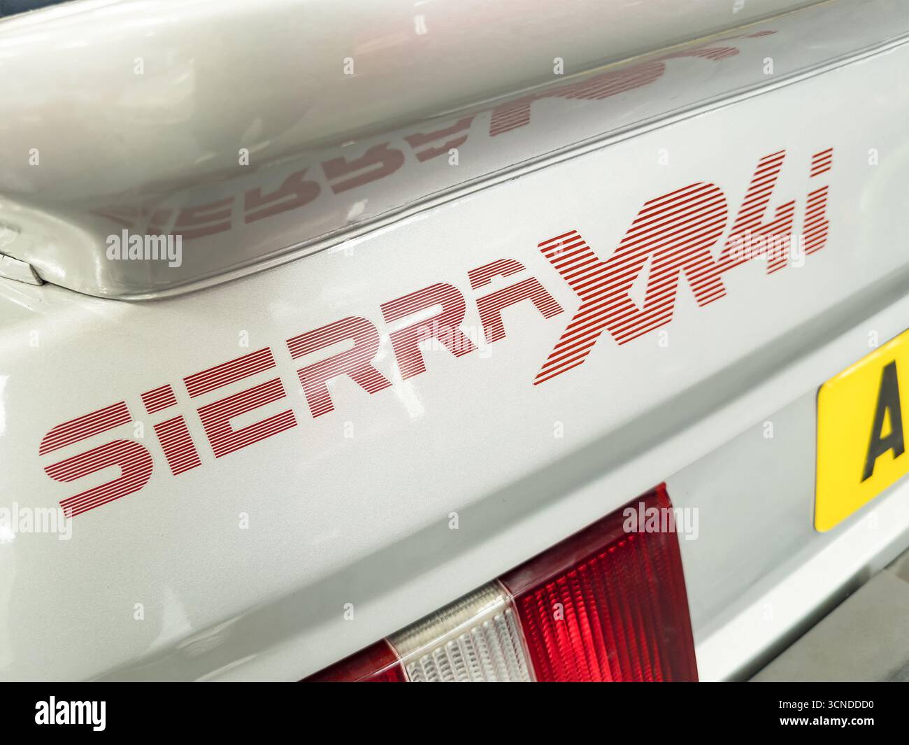 Close-up of the red Sierra XR4i logo on the rear of a vintage Ford Sierra car highlighting its iconic design and style - Smartphone Captured Stock Image