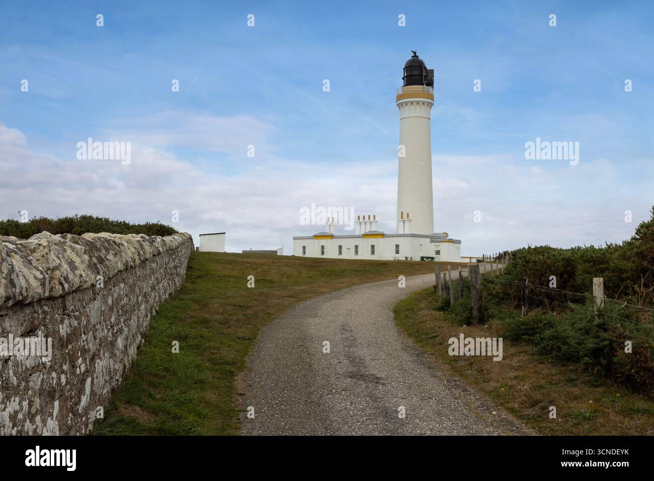The historic Covesea Lighthouse, an iconic white tower designed by Alan Stevenson, stands on a rugged headland overlooking the Moray Firth. Stock Photo