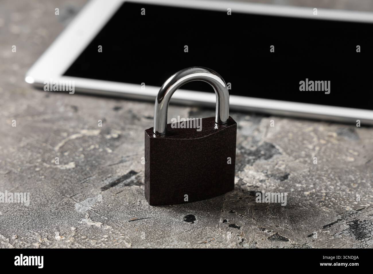 Padlock with tablet computer on grunge background, closeup. Cyber security concept Stock Photo