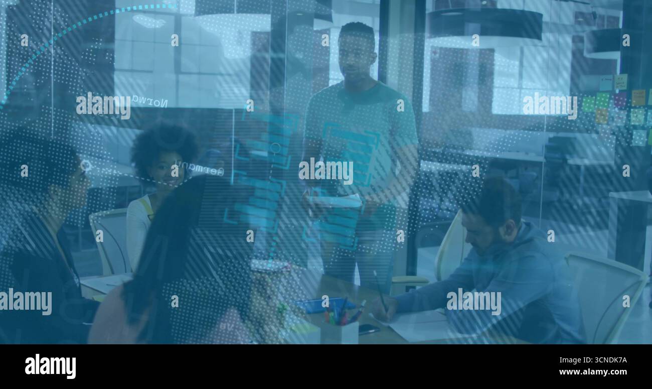 Presenting man holding printed documents at conference room table, with laptops and sticky notes Stock Photo