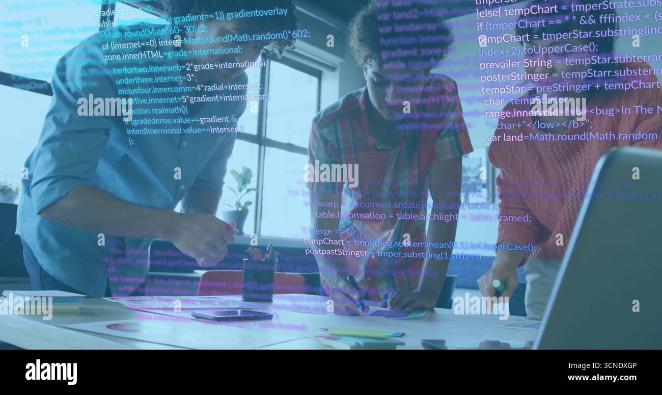 Collaborating software developers reviewing code on laptop at office desk, with pens, code overlay Stock Photo