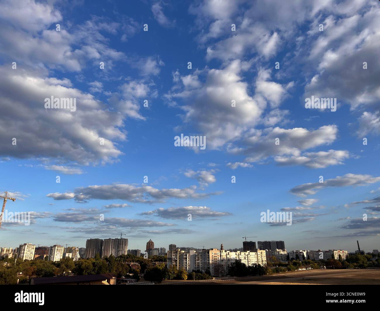 panorama of architecture and skyscrapers with a blue summer sky and white fluffy clouds - Smartphone Captured Stock Image