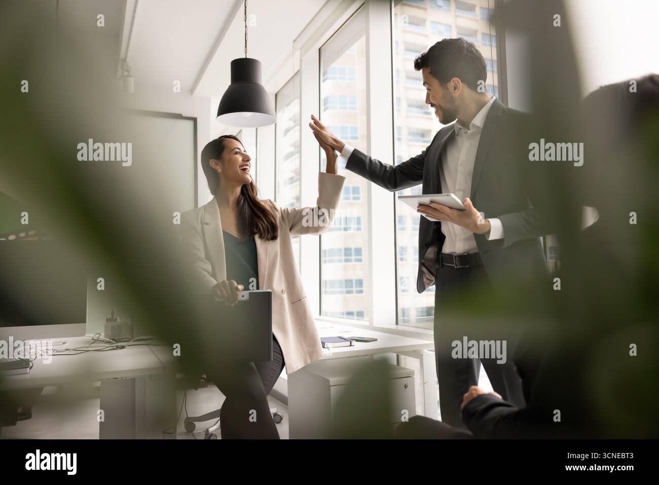 Two diverse excited colleagues making high five gesture Stock Photo