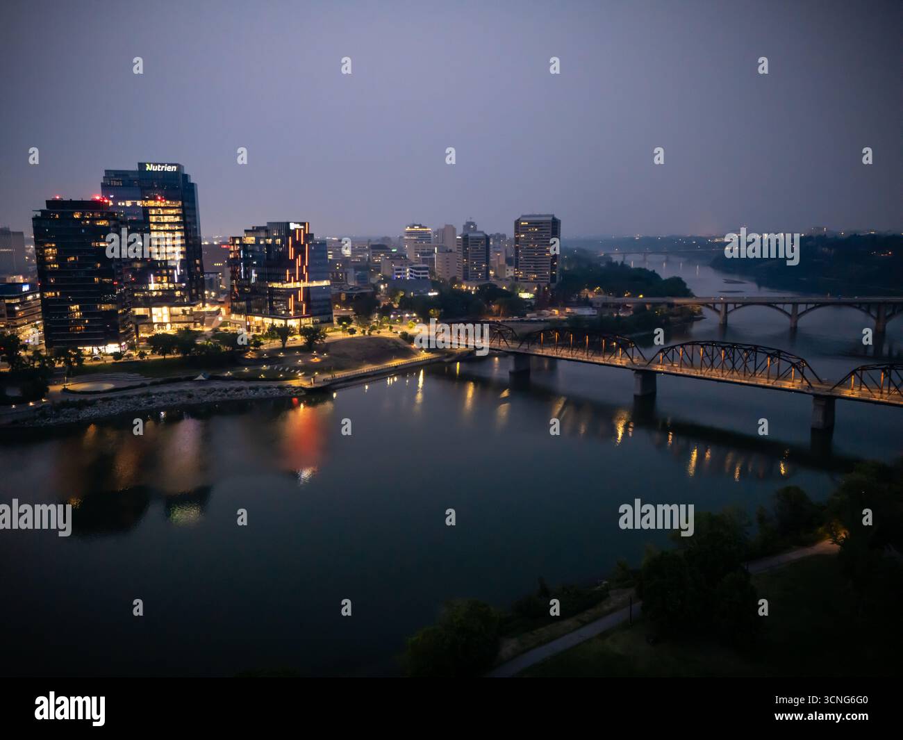 Aerial night view of downtown Saskatoon, Saskatchewan, featuring the city skyline, bridges, and illuminated streets. Stock Photo