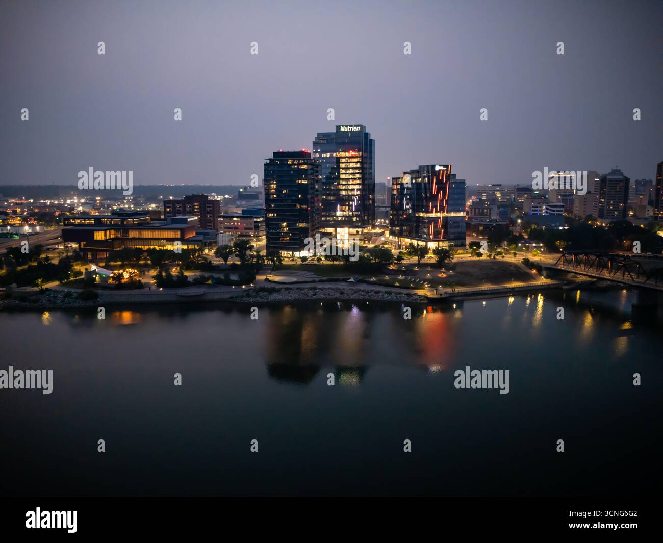Aerial night view of downtown Saskatoon, Saskatchewan, featuring the city skyline, bridges, and illuminated streets. Stock Photo