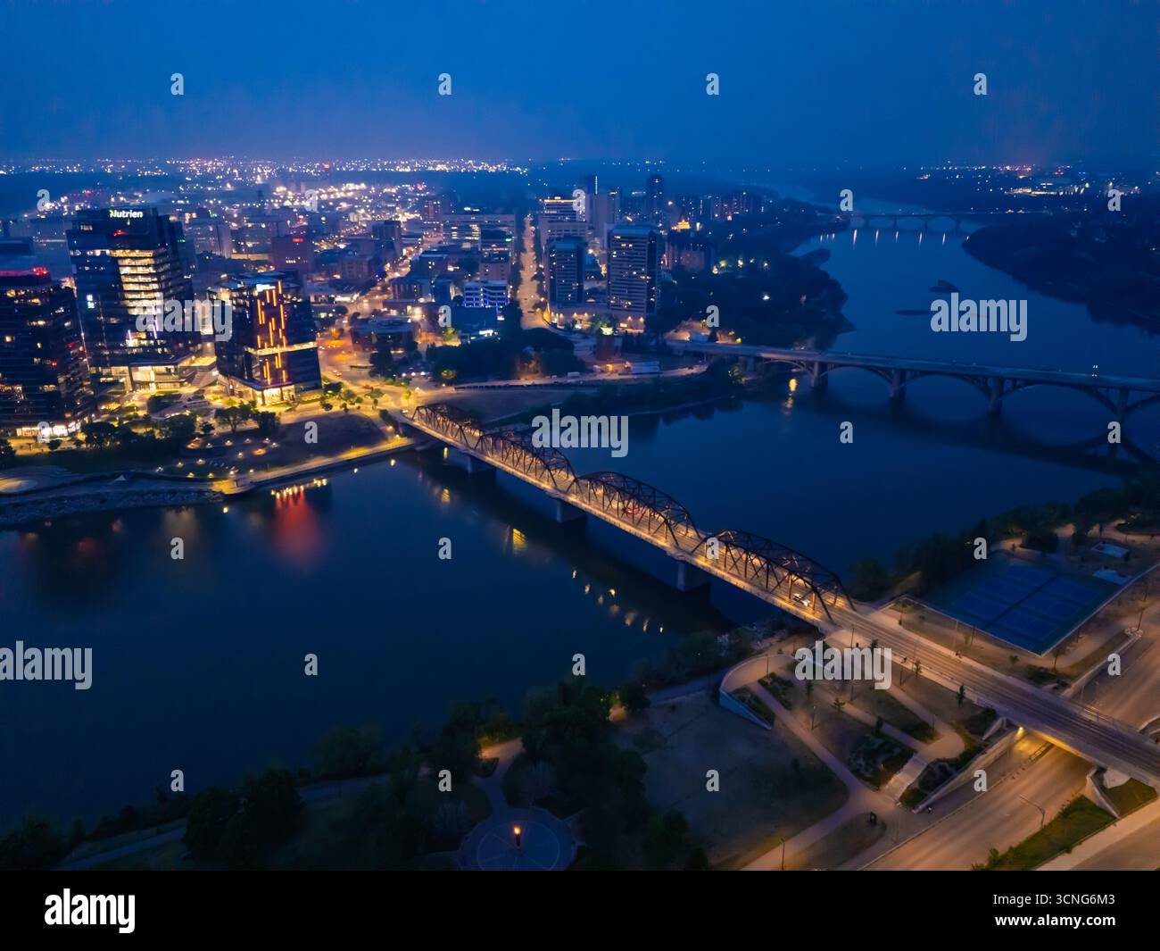 Aerial night view of downtown Saskatoon, Saskatchewan, featuring the city skyline, bridges, and illuminated streets. Stock Photo
