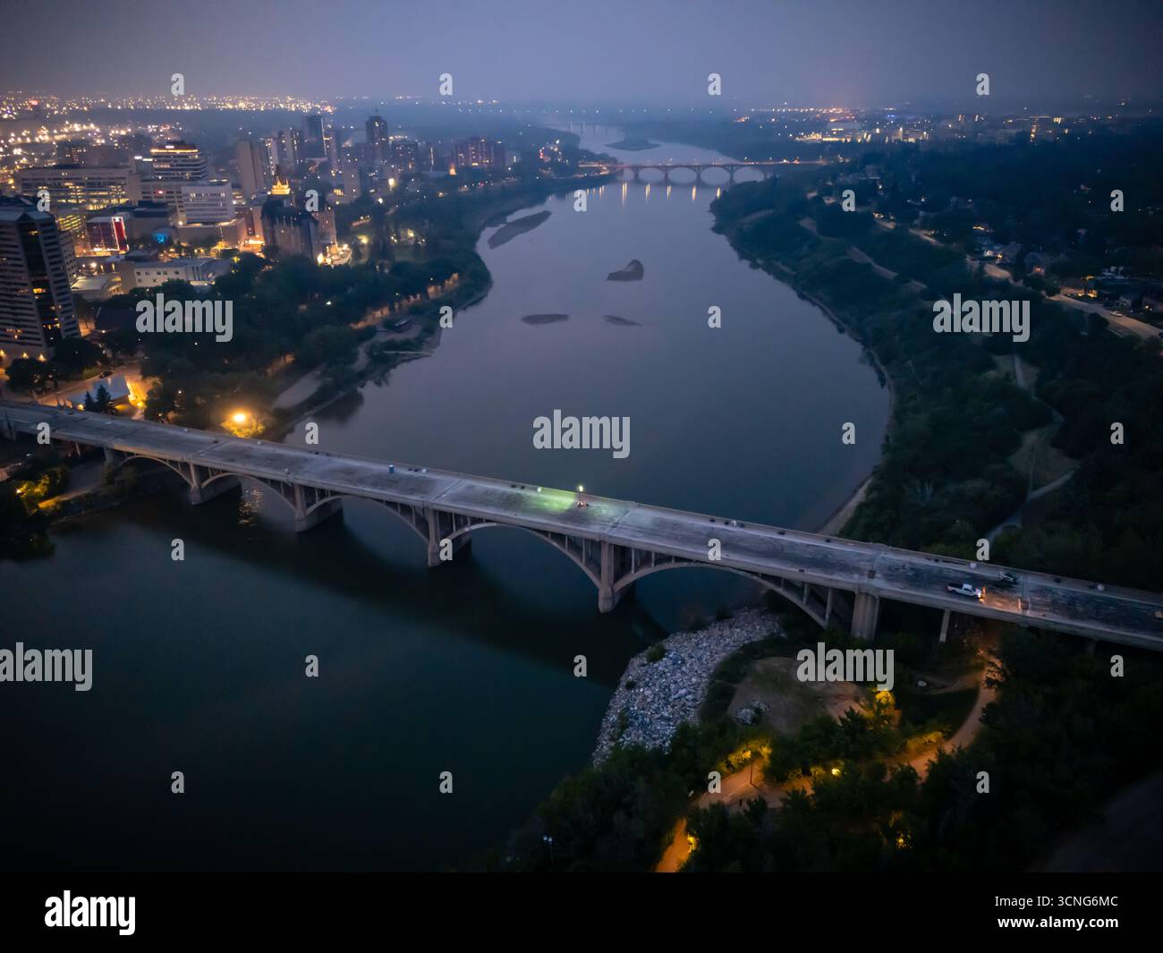Aerial night view of downtown Saskatoon, Saskatchewan, featuring the city skyline, bridges, and illuminated streets. Stock Photo