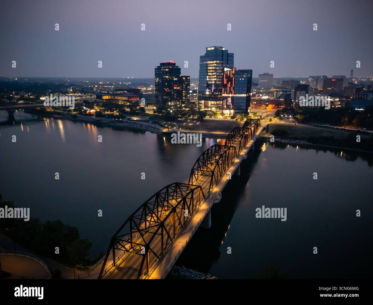 Aerial night view of downtown Saskatoon, Saskatchewan, featuring the city skyline, bridges, and illuminated streets. Stock Photo