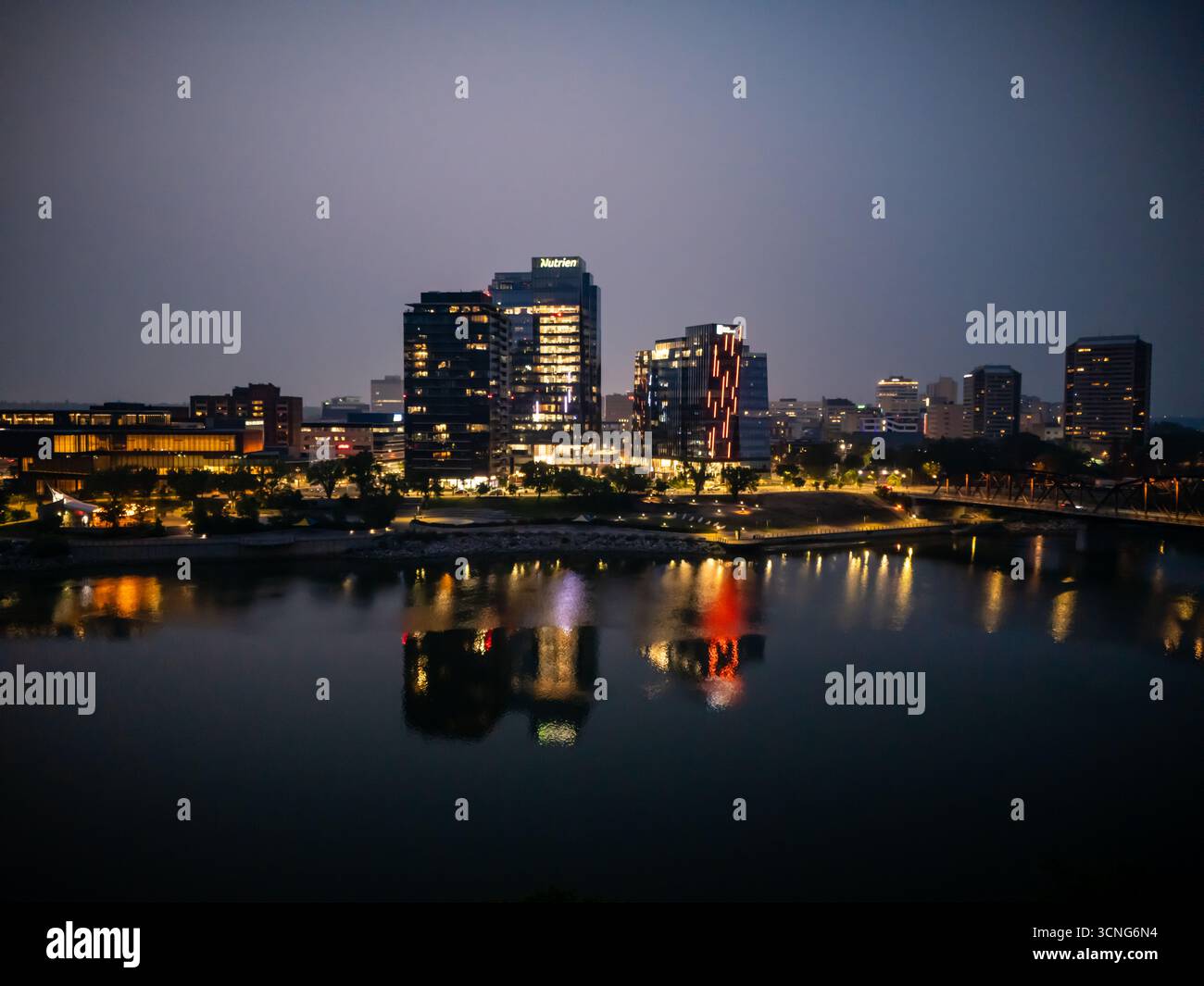 Aerial night view of downtown Saskatoon, Saskatchewan, featuring the city skyline, bridges, and illuminated streets. Stock Photo