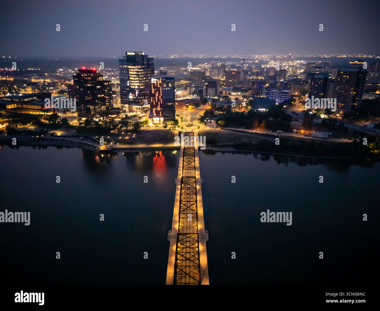 Aerial night view of downtown Saskatoon, Saskatchewan, featuring the city skyline, bridges, and illuminated streets. Stock Photo