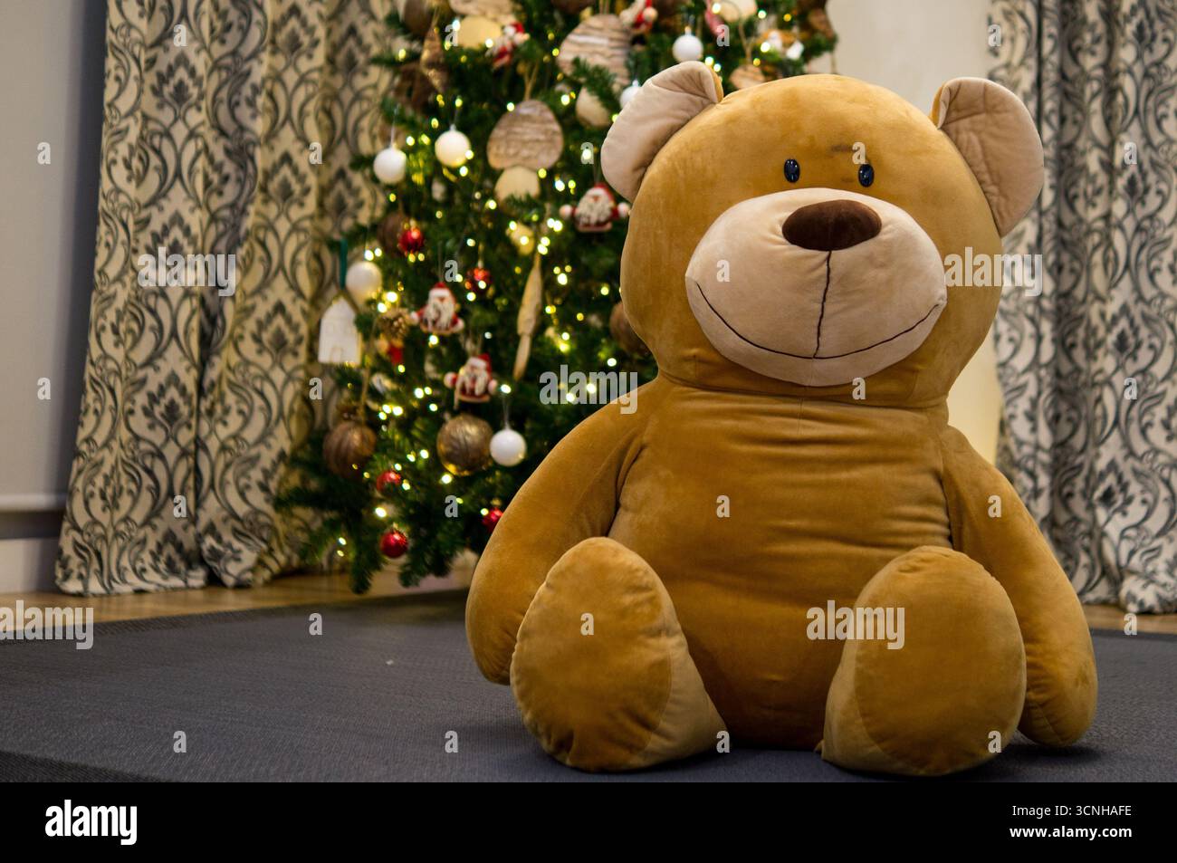 giant teddy bear in front of the Christmas tree Stock Photo - Alamy