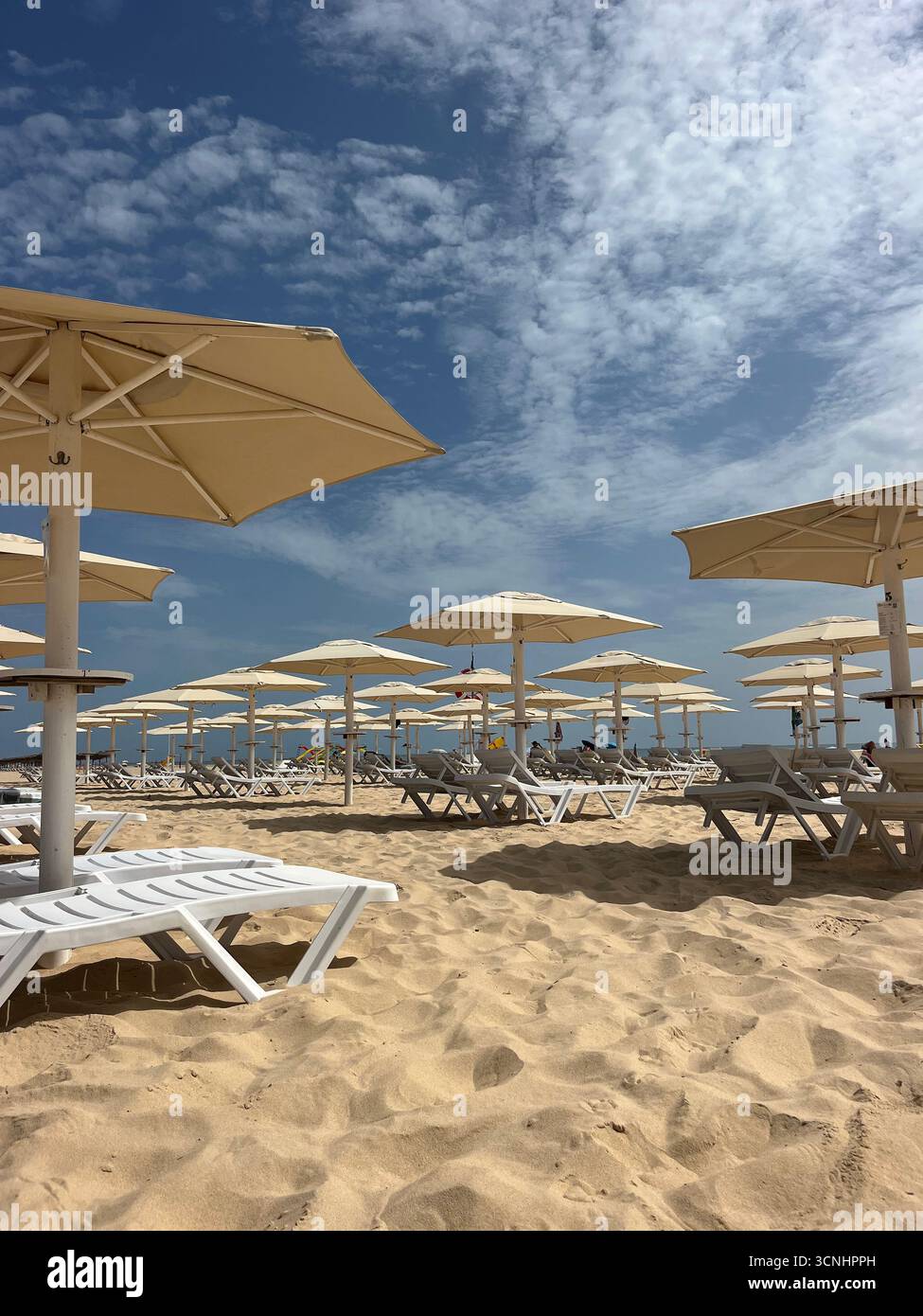 Sunny Day at Monte Gordo beach in Algarve, with Rows of Umbrellas and Sunbeds - Smartphone Captured Stock Image