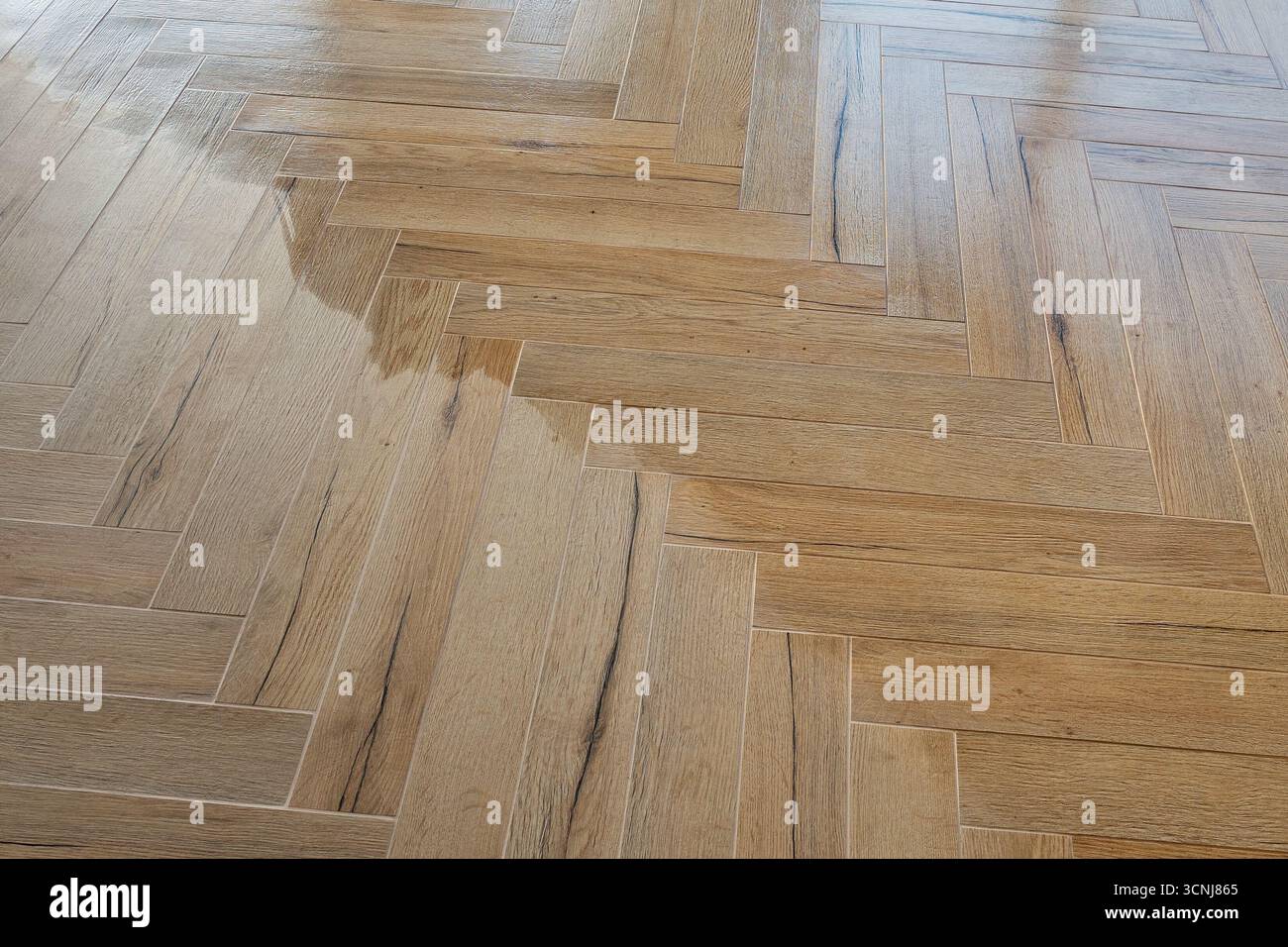 Modern herringbone floor tiles being impregnated Stock Photo