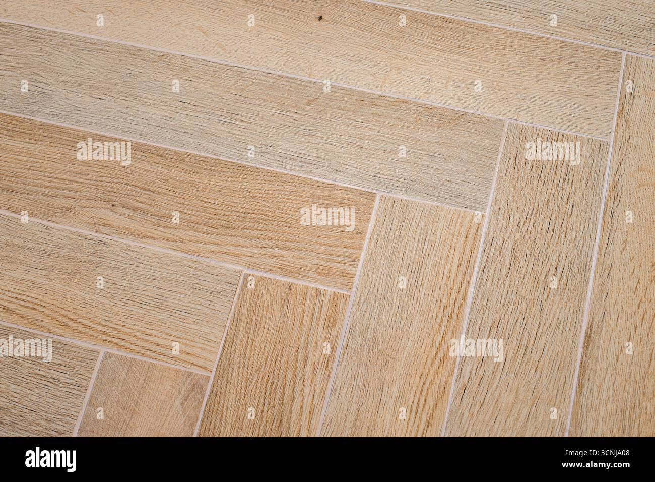 Herringbone floor with rectangular tiles arranged in broken zigzags Stock Photo