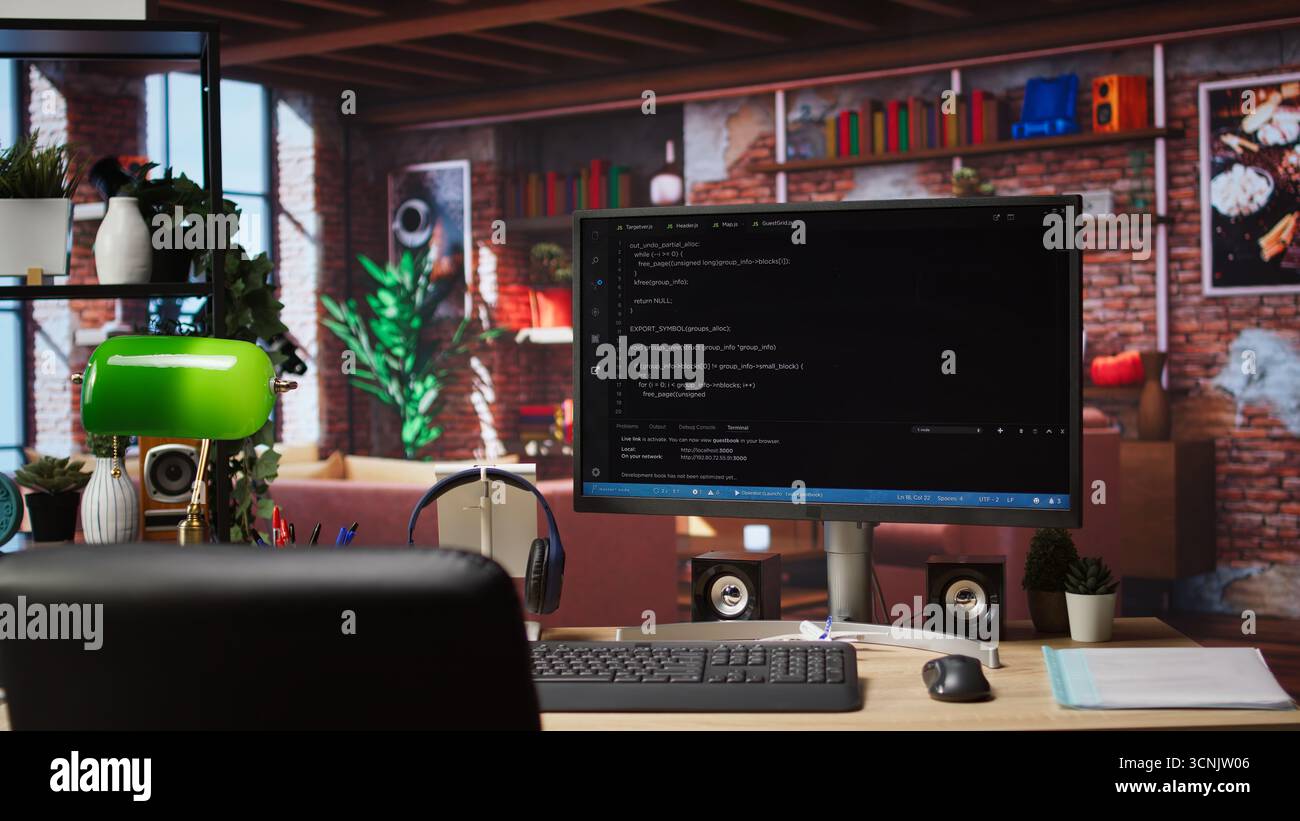 Coding interface shown on computer screen on desk in bright home office. Command lines written in code editor program UI on PC display in modern cozy home living room workspace Stock Photo