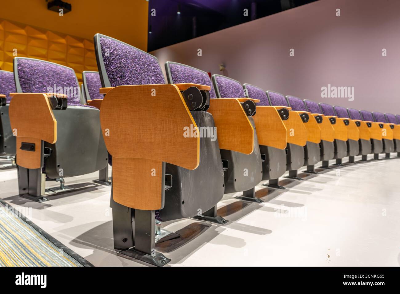 Purple padded auditorium seats, chairs with table, gray concrete floor ...