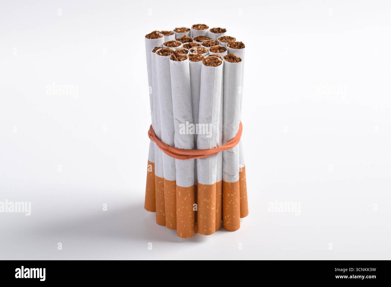 A bundle of cigarettes tied with a rubber band on a white background,  symbolizing smoking addiction, health risks, and the concept of quitting  smoking Stock Photo