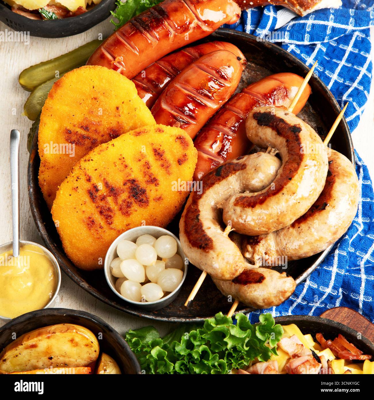 Various austrian dishes- schnitzel, sausages, potatoes, Knodel, salad and sauces on a light background. Top view. Stock Photo