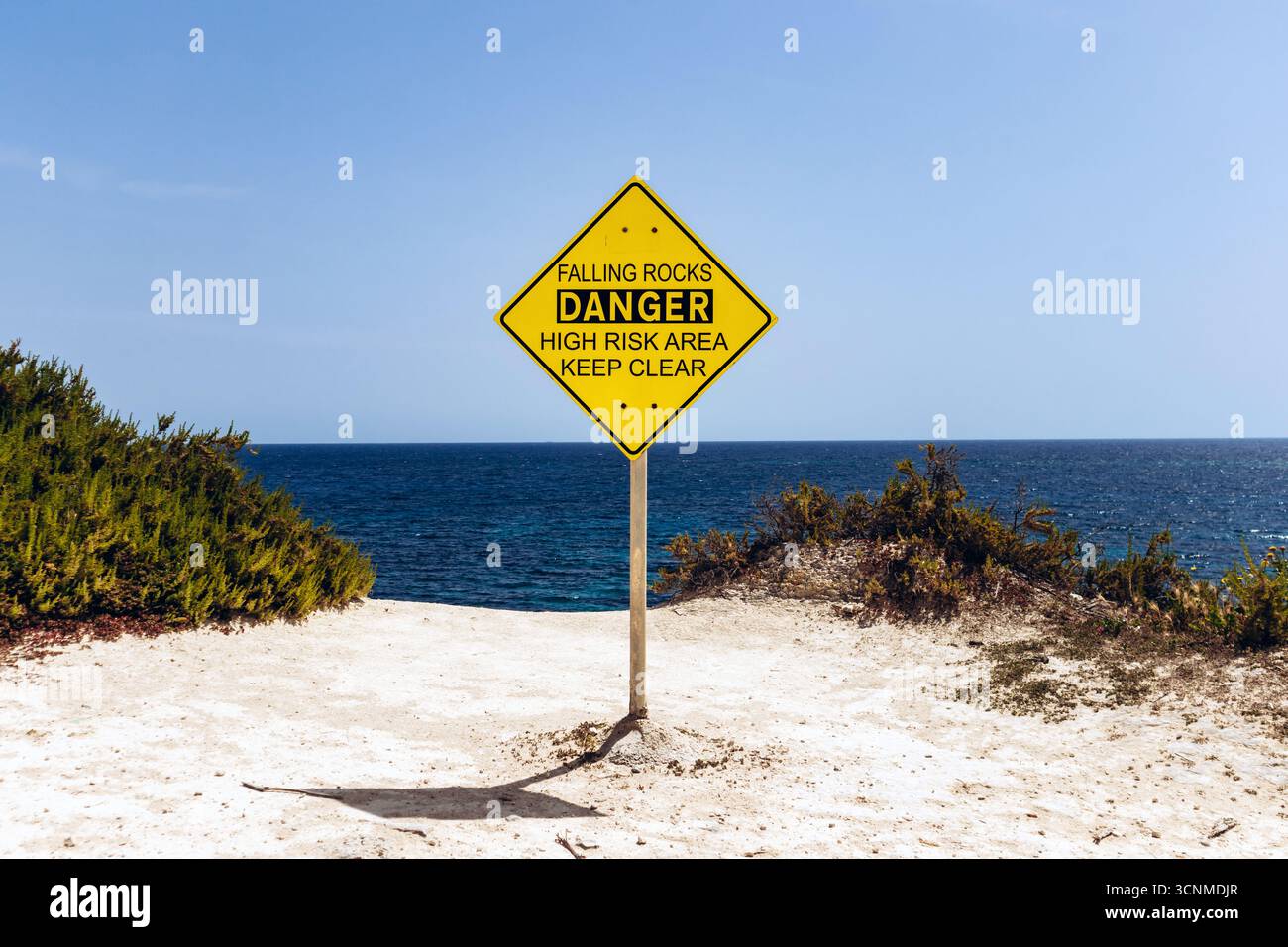 Bright yellow warning sign reading “Falling Rocks – Danger High Risk ...