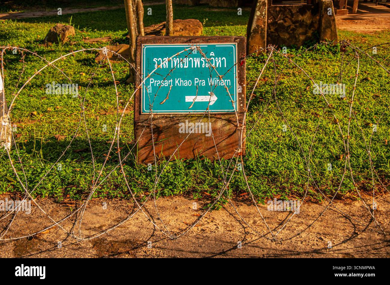 Razor wire protects a bilingual sign to Khao Phra Wihan National Park, Sisaket Province, Issan, Thailand. © Kraig Lieb Stock Photo