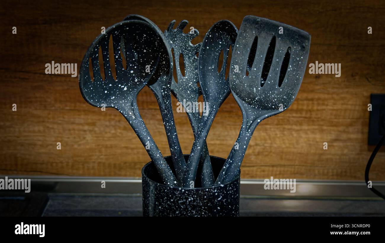 Used black with white dots plastic kitchen utensils Stock Photo