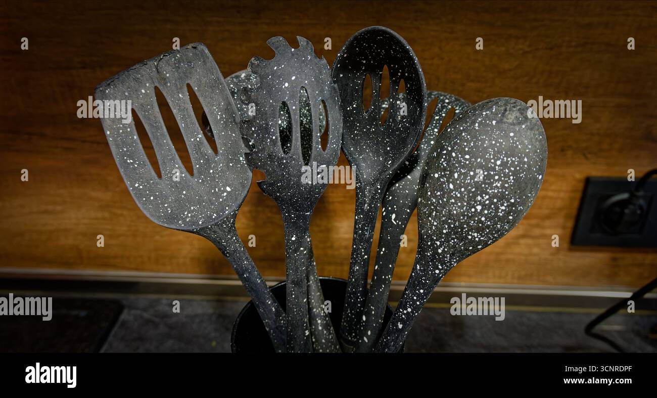 Used black with white dots plastic kitchen utensils Stock Photo