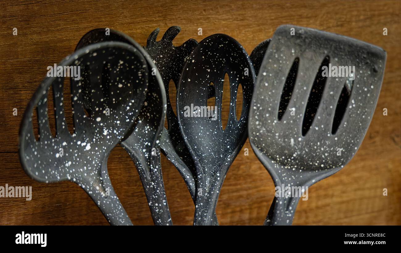 Used black with white dots plastic kitchen utensils Stock Photo