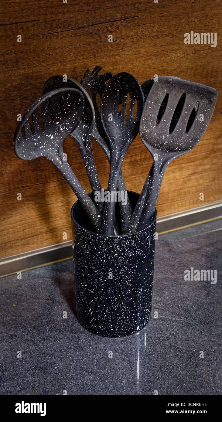 Used black with white dots plastic kitchen utensils Stock Photo