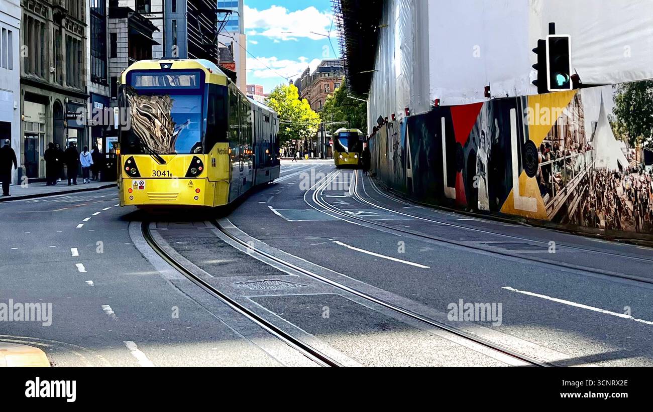 A Metrolink tram passes Manchester town hall in John Dalton Street Stock Photo