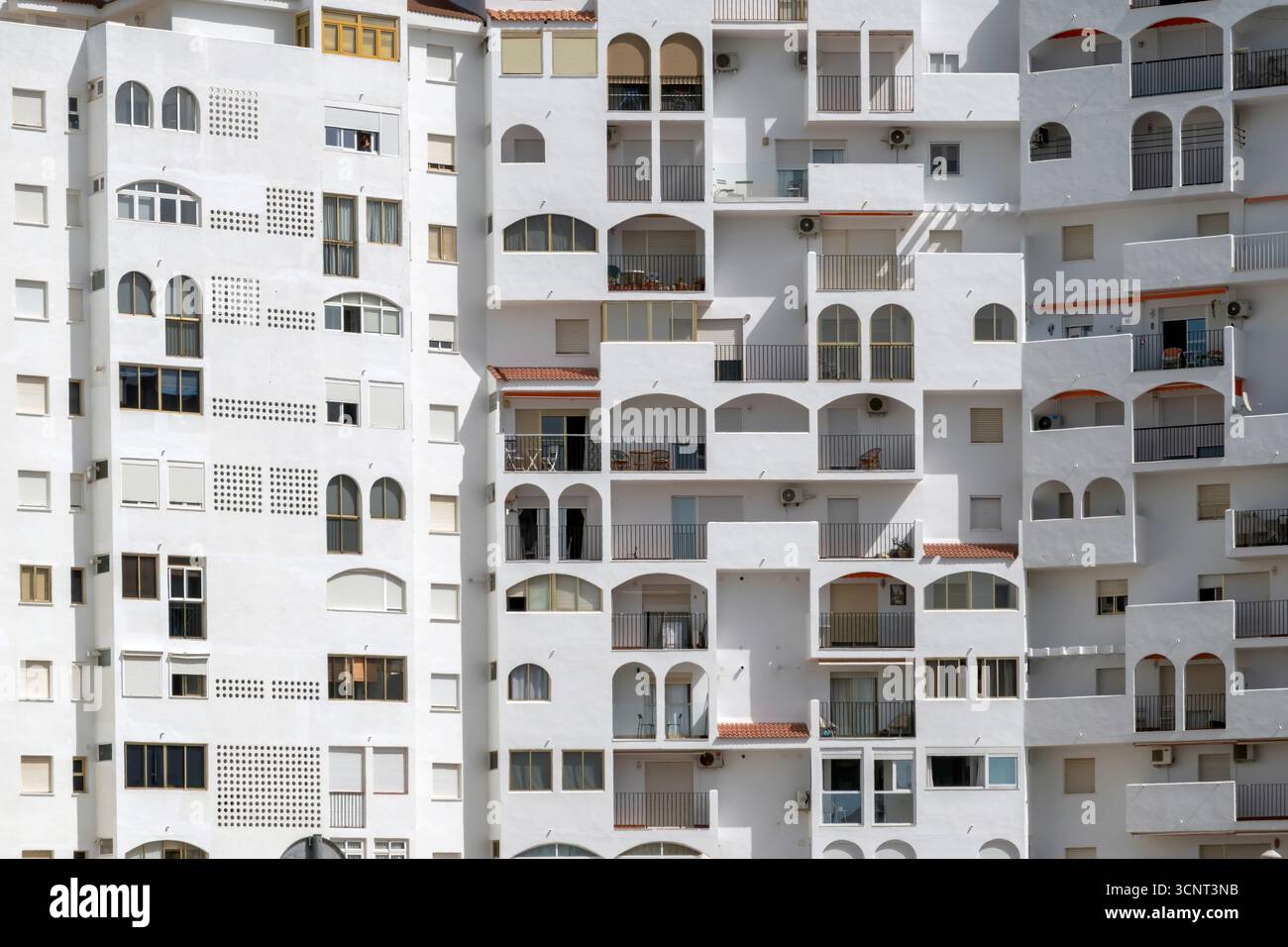 White residential building facade with varied balconies and windows ...
