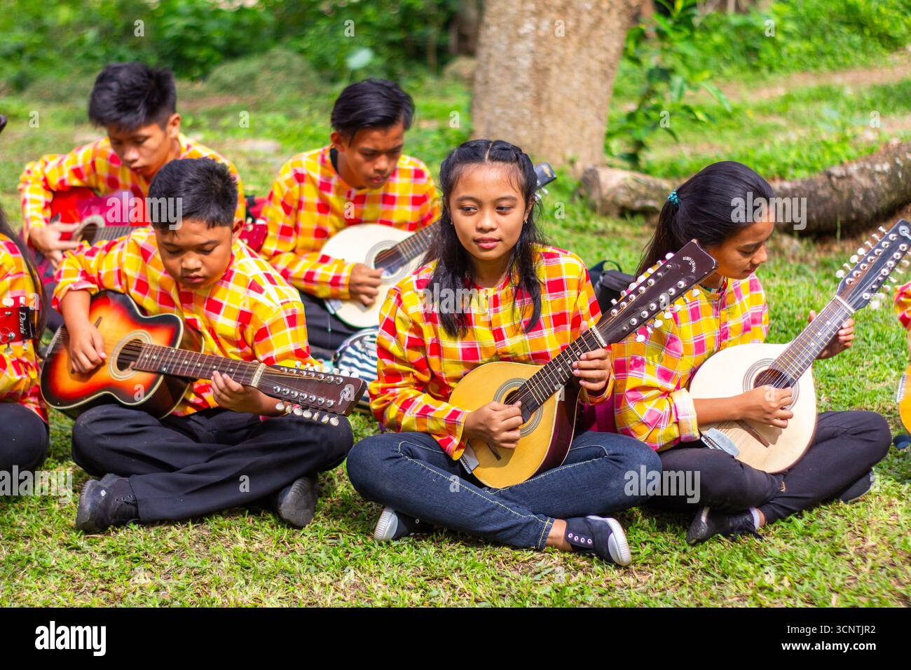 Group of young rondalla players performing with traditional stringed ...