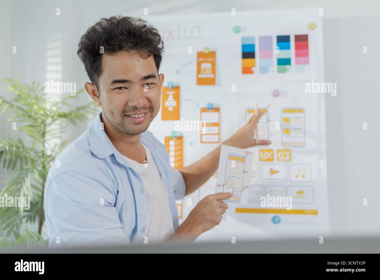 A focused designer is working on UX/UI design ideas, analyzing color ...