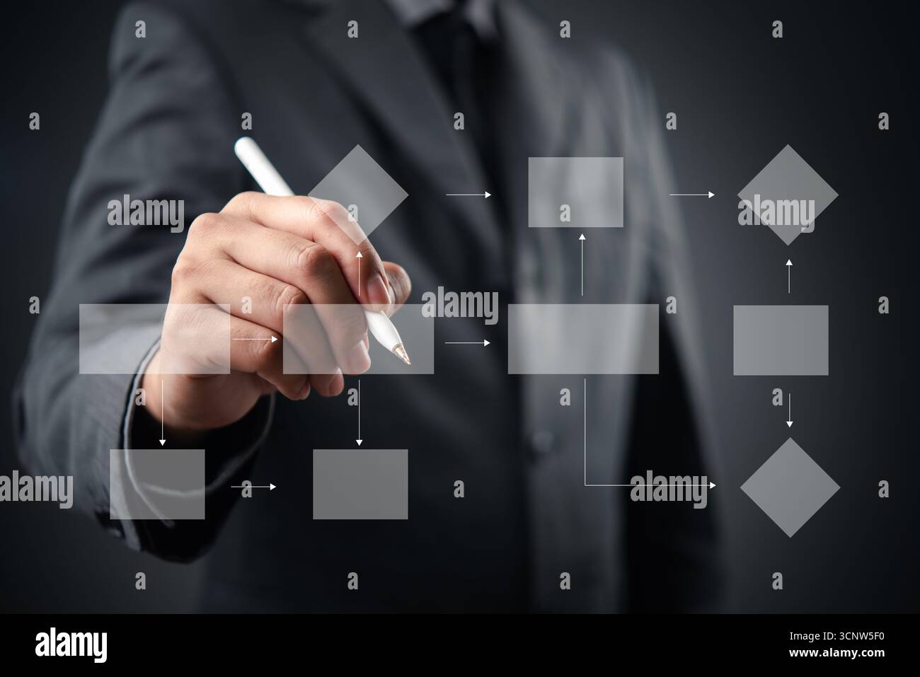 Businessman drawing a digital flowchart with a pen, illustrating the ...