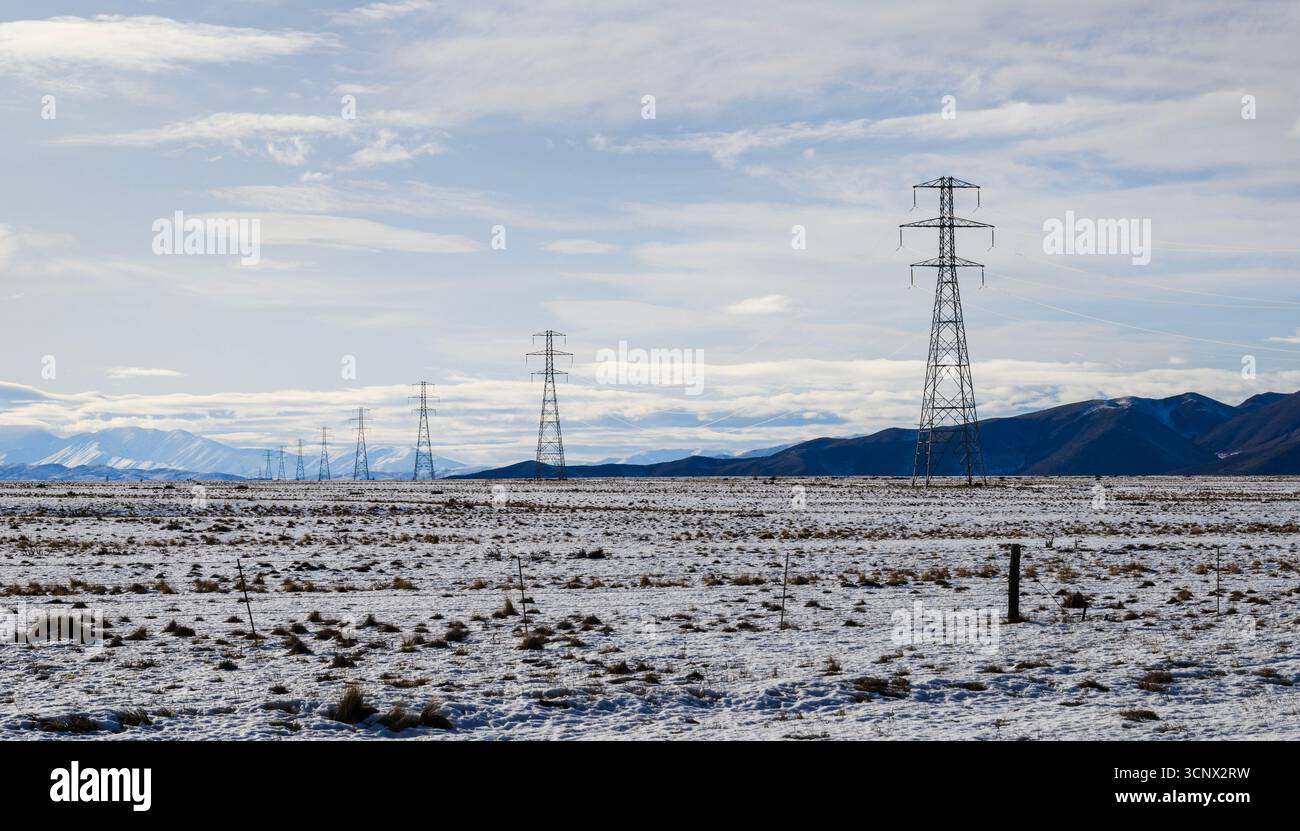 Power pylon and power lines on snow-covered field in winter. Twizel ...
