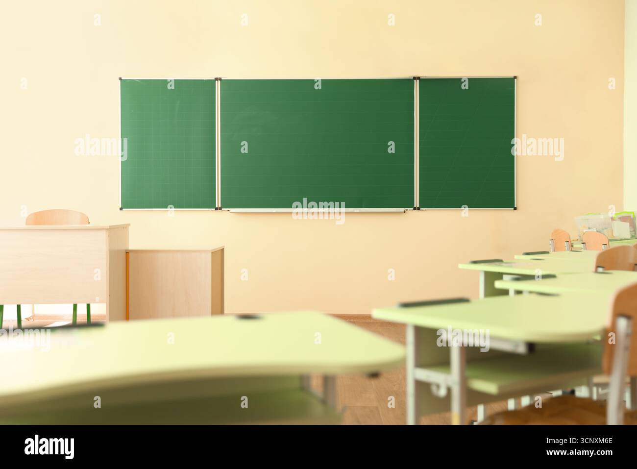 Desks with chairs and green chalkboard in classroom Stock Photo - Alamy