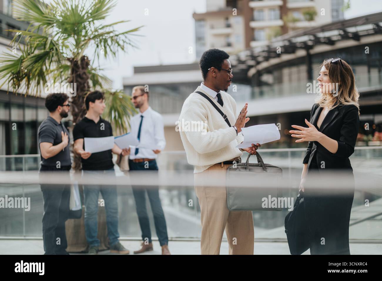 Professionals Engaging in Collaborative Discussion in a Modern Outdoor Setting Stock Photo