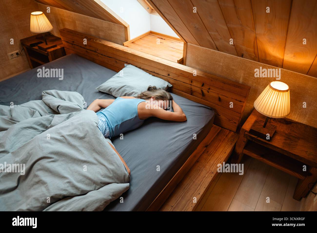 A serene and calming bedroom scene, where a person is peacefully resting in a warm and cozy environment Stock Photo