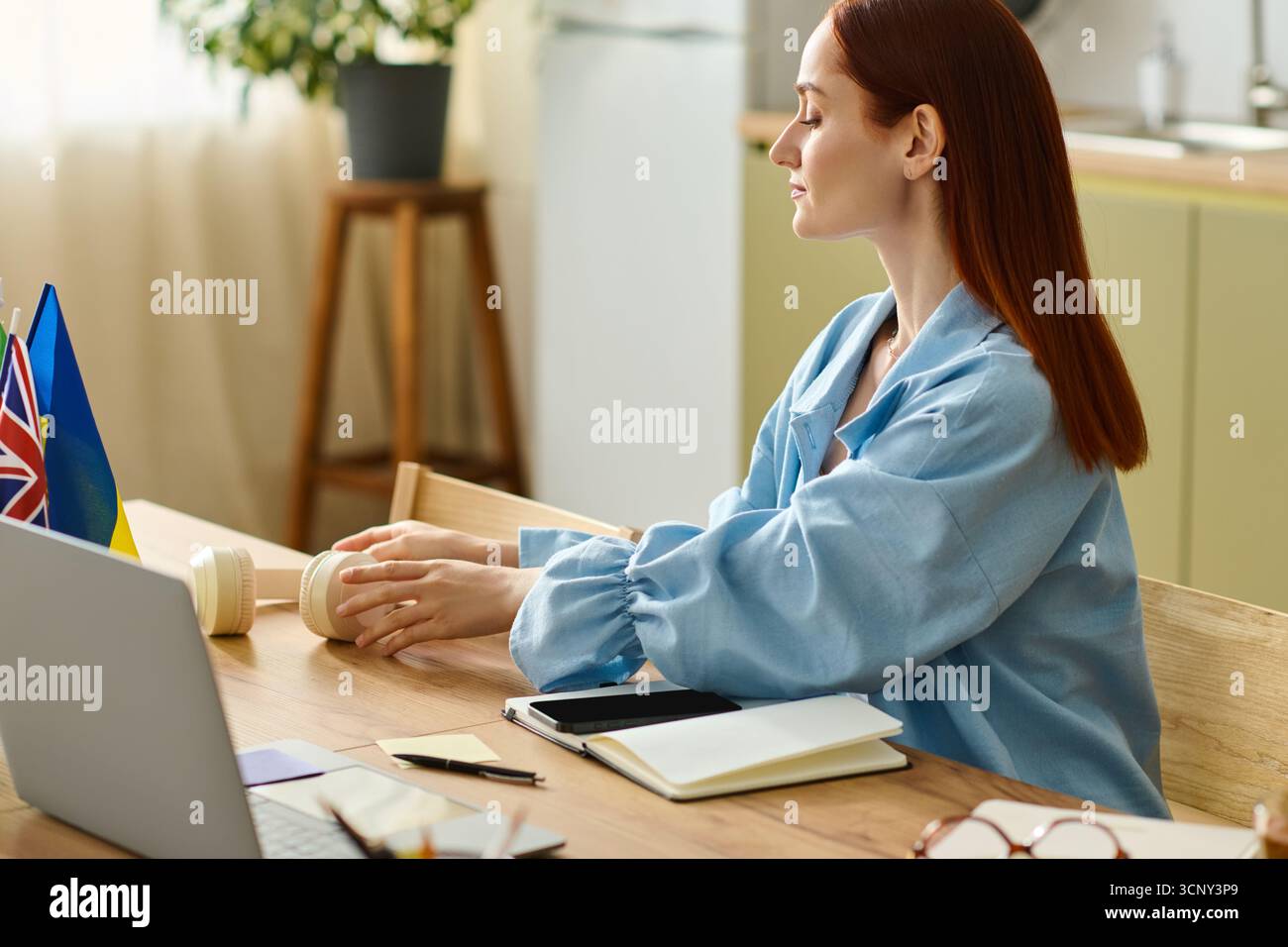 Red-haired language teacher engages students online while working from her comfortable home setting. Stock Photo
