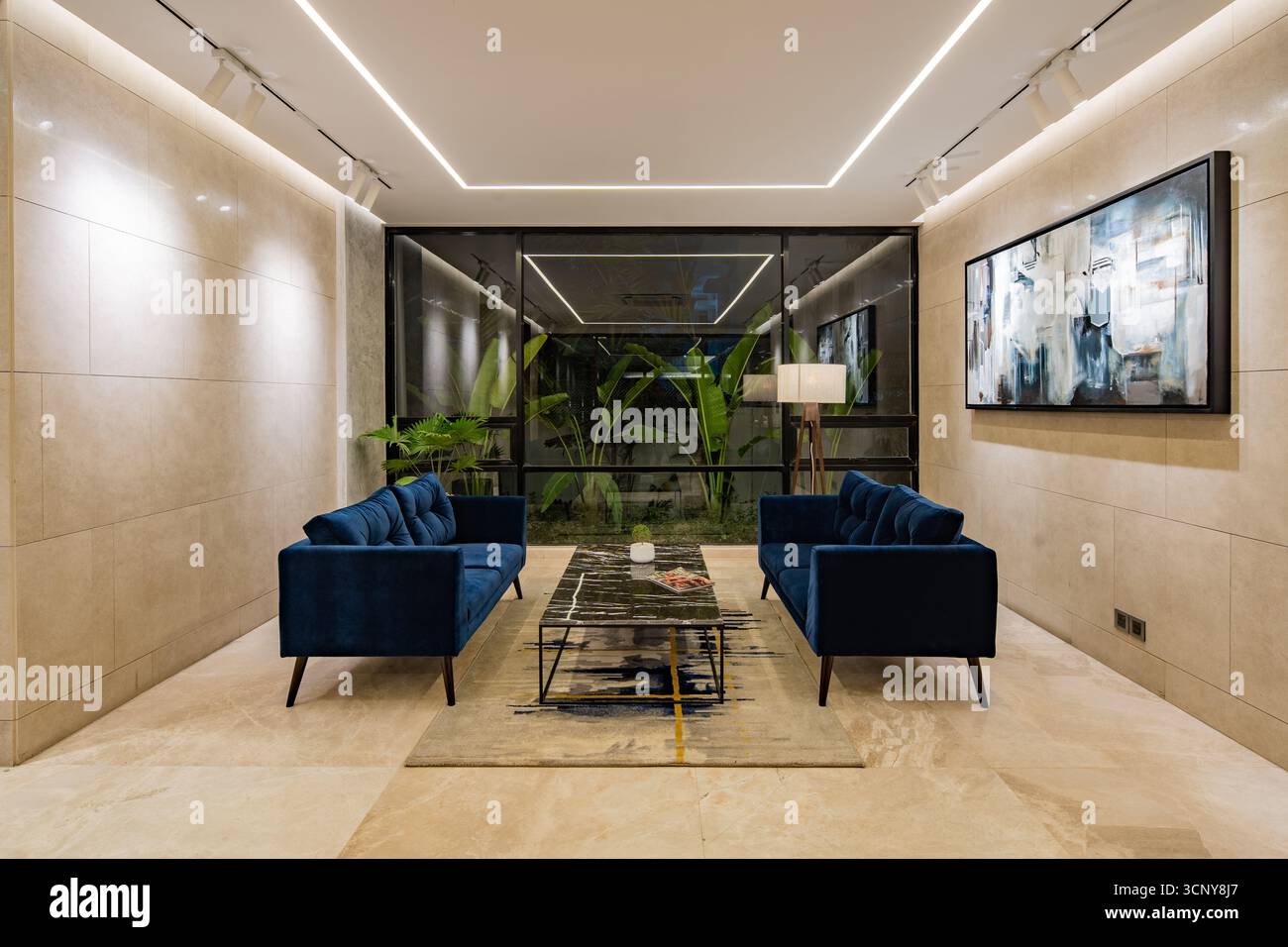 A sleek and luxurious modern lounge area with two symmetrical blue ...