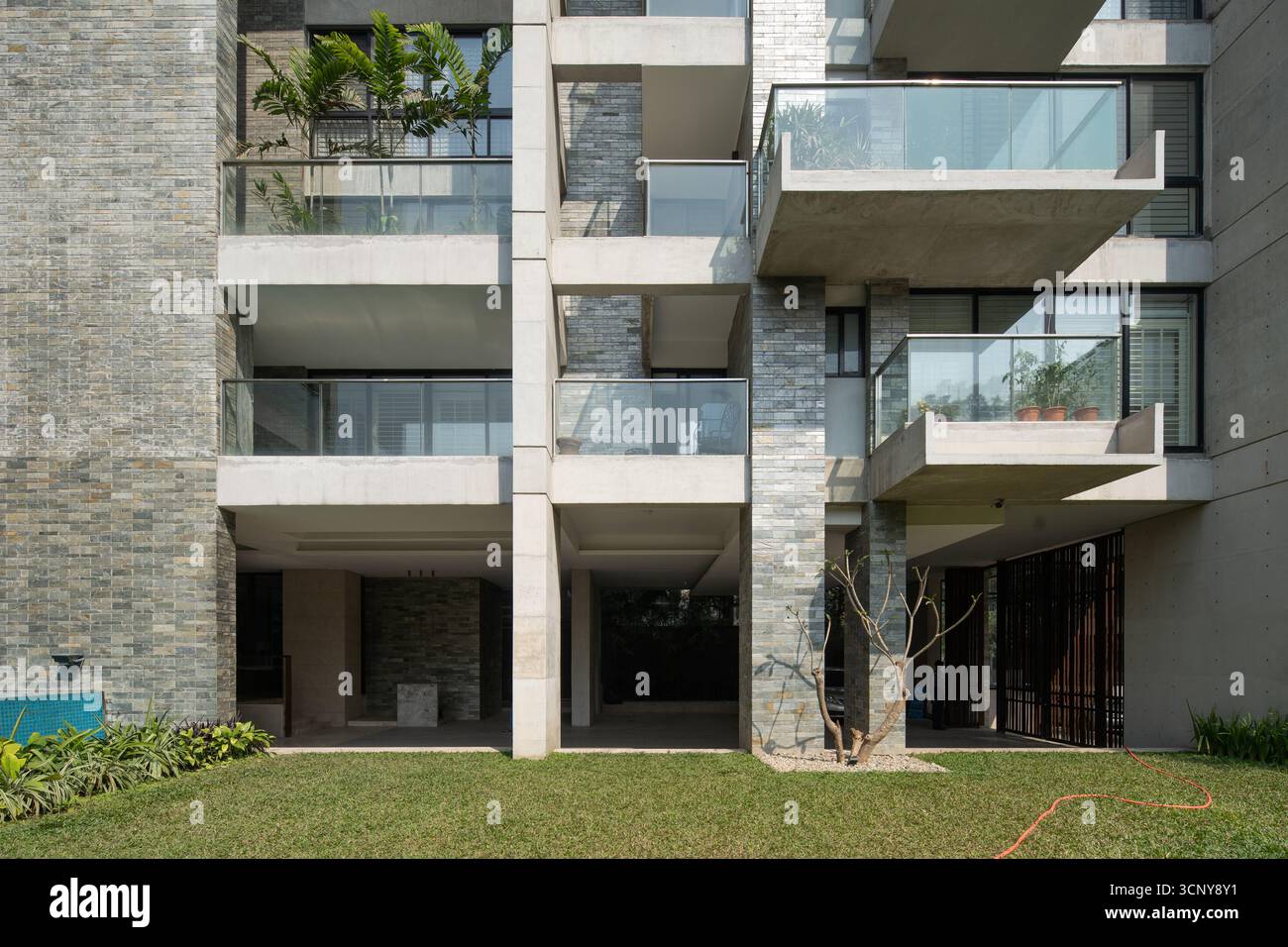 A wide, straight-on view of a modern apartment building with a textured ...
