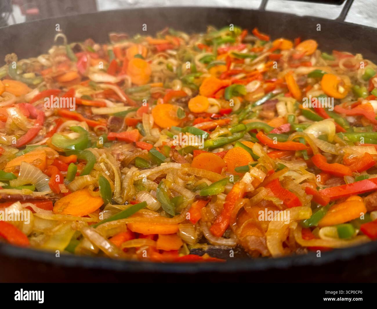 A vibrant stir-fry of chopped vegetables and diced meat cooking in a large pan, featuring carrots, peppers and onions. - Smartphone Captured Stock Image A vibrant stir-fry of chopped vegetables and diced meat cooking in a large pan, featuring carrots, peppers and onions. - Smartphone Captured Stock Image