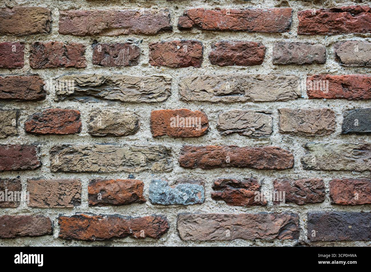 Old, weathered, colorful brick wall pattern or background. Front view, close up, no people Stock Photo