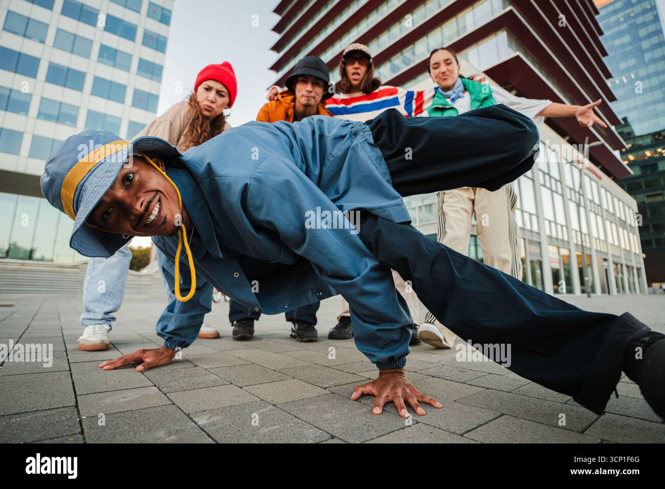 An energetic breakdancer showcases an impressive freeze move, captivating fellow dancers and onlookers with their incredible skills and enthusiasm for Stock Photo