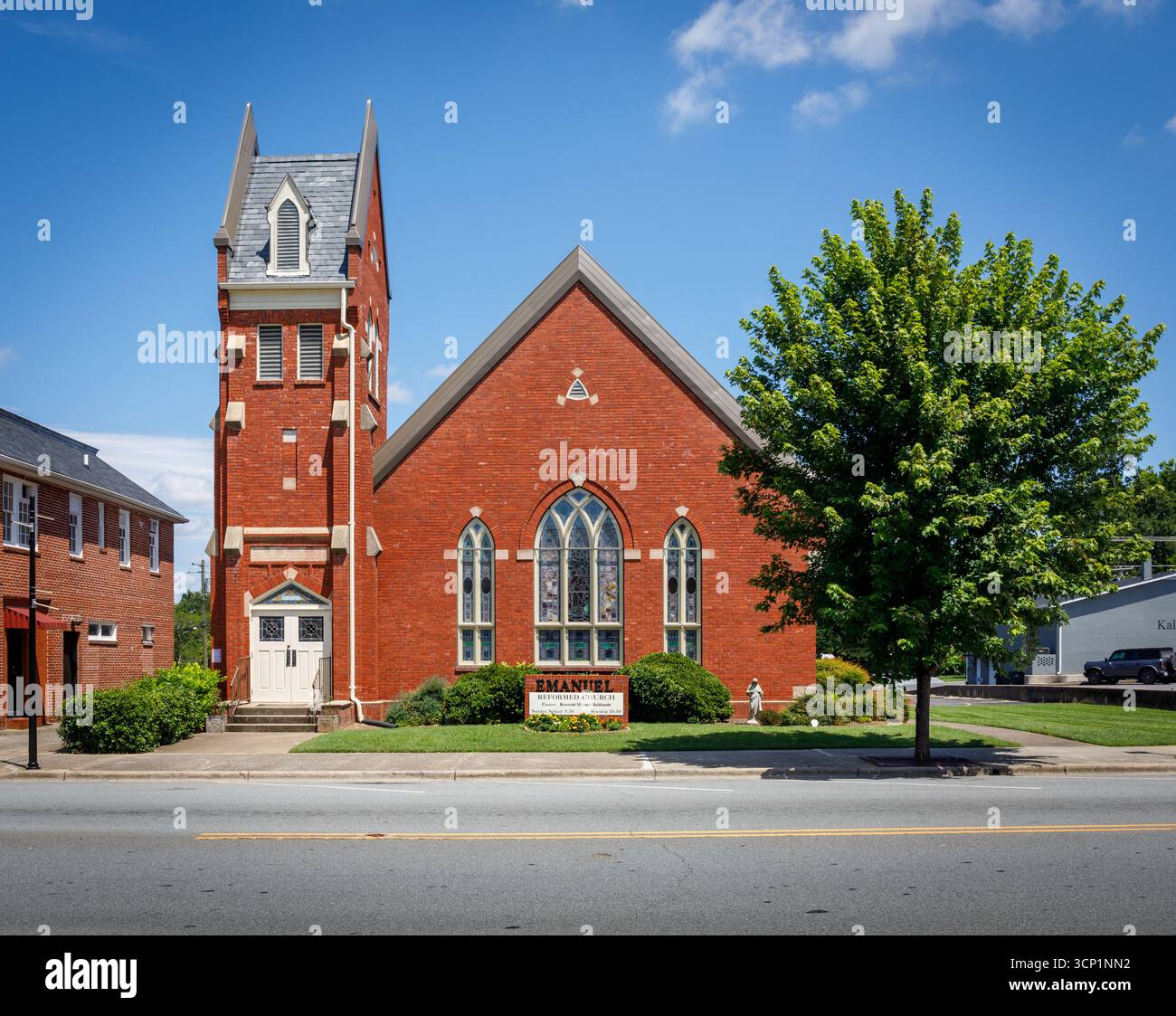 Lincolnton, North Carolina, USA-14 July 2025:  Emanuel Reformed Church, red brick Late Gothic Revival building, with brick bell tower, on Main Street Stock Photo